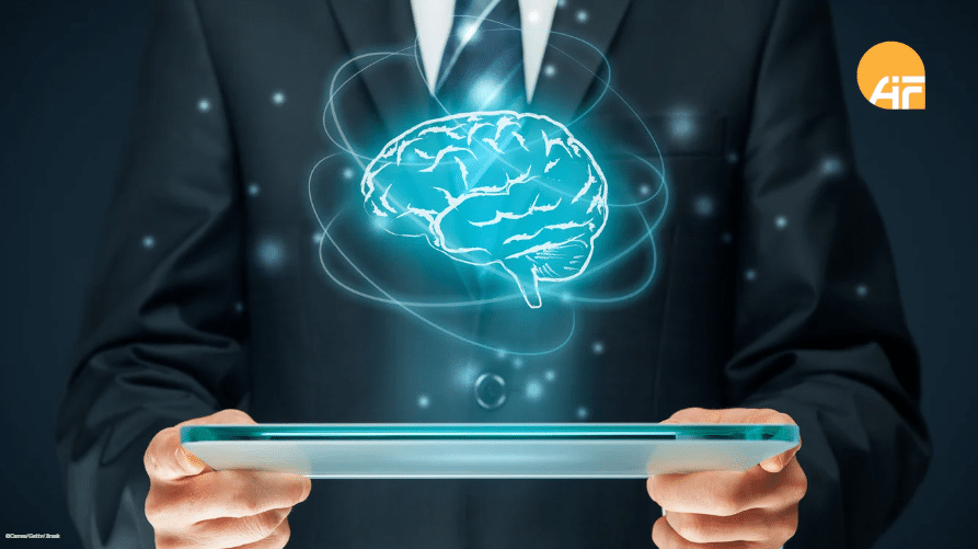 Über einem Tablet, dass gehalten wird, schwebt ein digitales Gehirn.