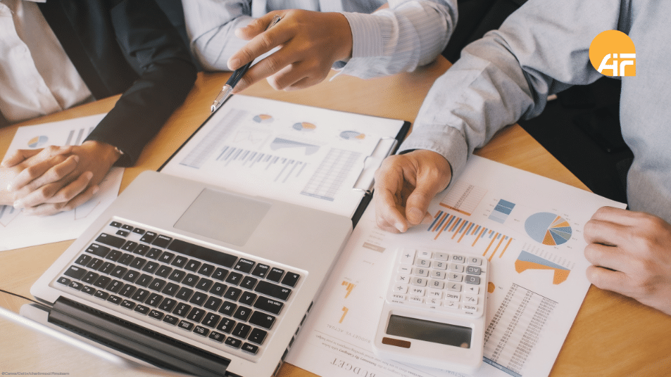 Ein Arbeitstisch, an dem mehrere Personen sitzen und arbeiten.