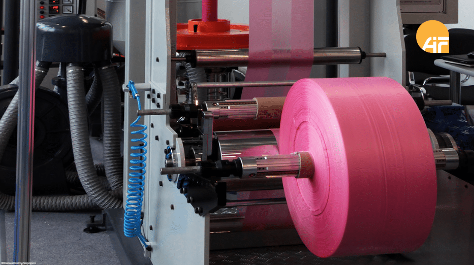 Verpackungsmaterial auf einer Rolle in einer Werkhalle.